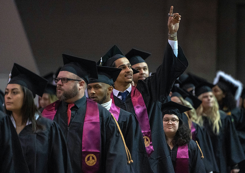 Students smile as they receive diplomas during Fall 2019 commencement