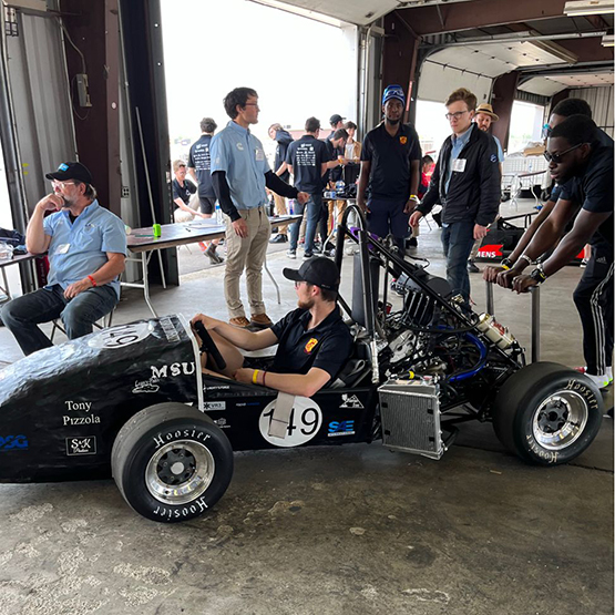 MSU Texas FSAE checks out their car in the garage at the competition in Michigan.