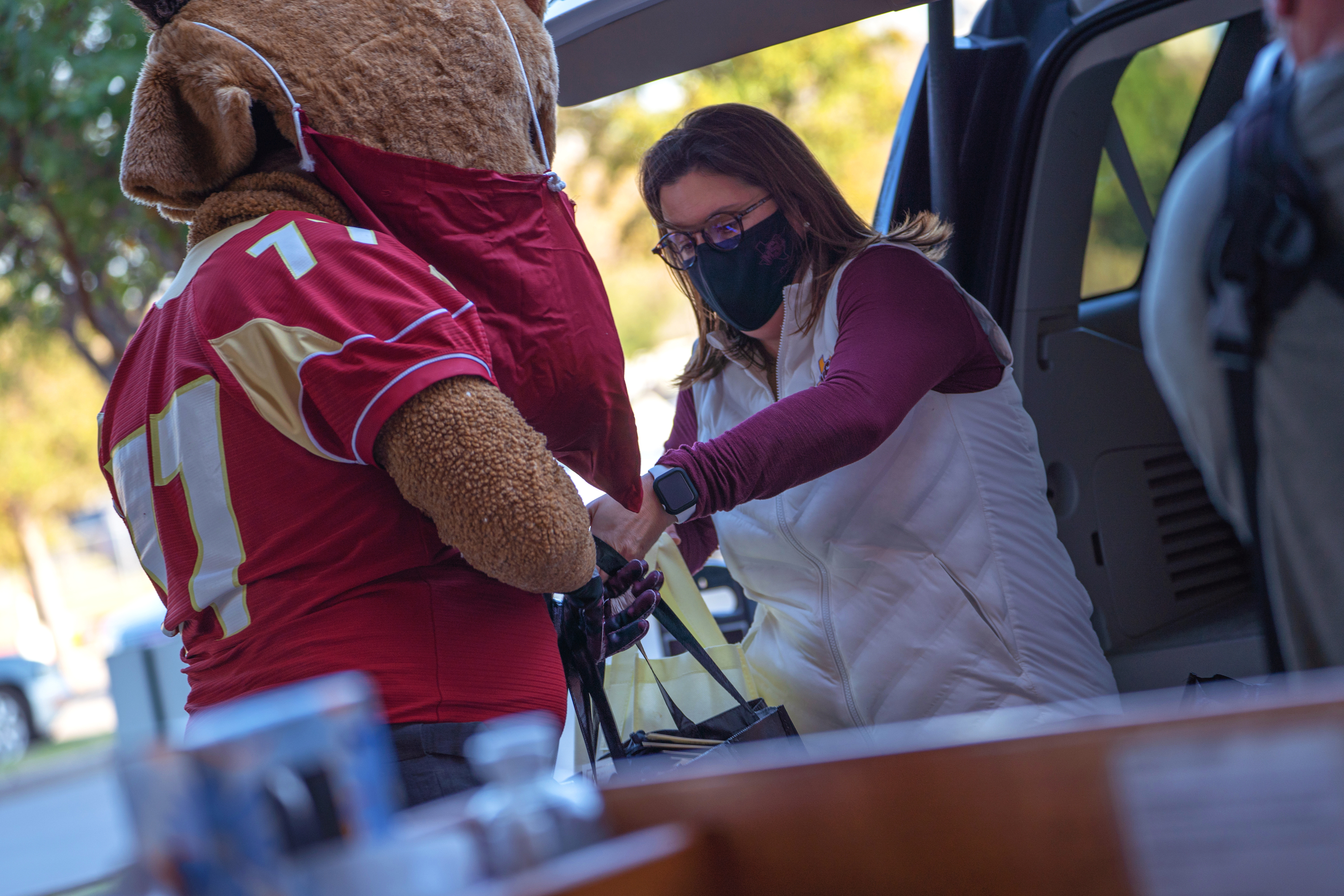 Maverick and Reagan Foster, Chair of the MSU Texas Staff Senate and Assistant Director of Athletics for Student Athletes and Community Outreach, unload bags of full of masks to present to representatives at United Regional, Hospice of Wichita Falls, and Kell West Regional Hospital.