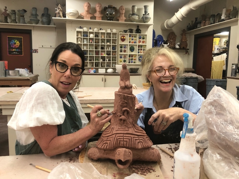 Karne Kimbell and MSU resident ceramic artist Pamela Moller sculpt a piece of clay. 