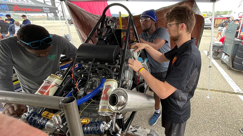 FSAE team members Hebadiah Warner, Sharome Burton, and Trevor Snyder put the final touches on the car ahead of the second technical inspection. 