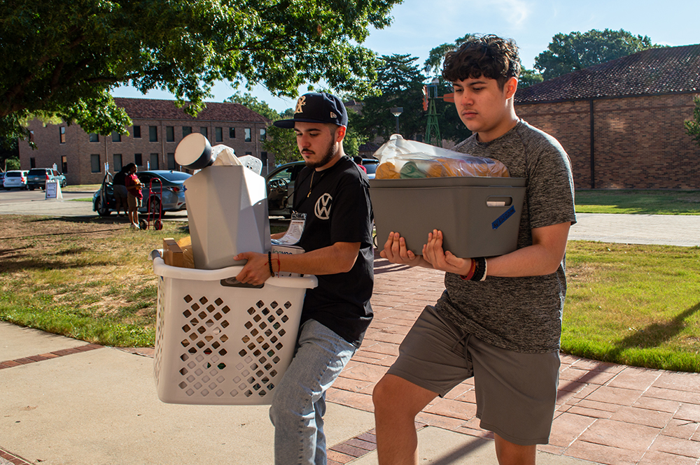 Mustangs Move In volunteers help carry bags in