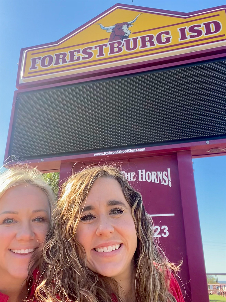 AHEC at Forestburg ISD with school sign behind AHEC personnel