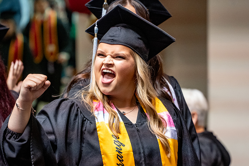 Graduate excitedly celebrates in December 2024