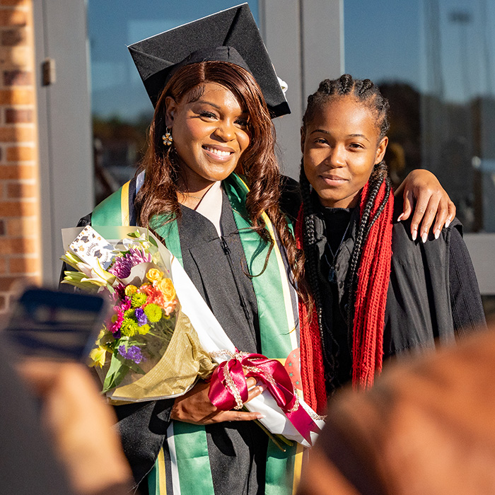 Graduate smiles at D.L. Ligon Coliseum