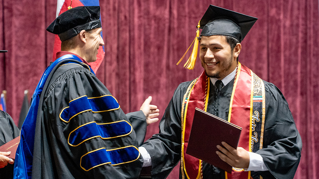 Luis Lagos on the commencement stage at D.L. Ligon Coliseum on December 14, 2024