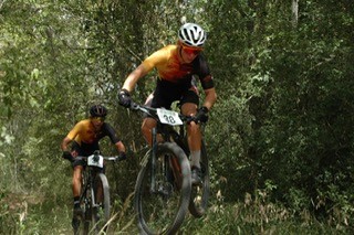MSU Cylists come up a dusty trail in the woods