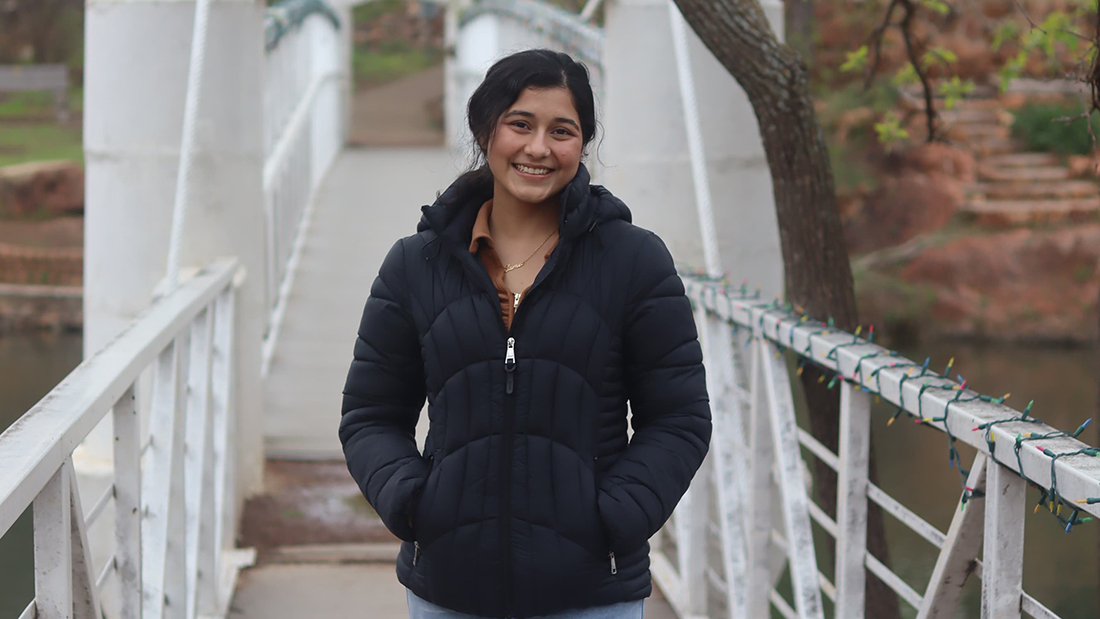 Sami stands on a bridge