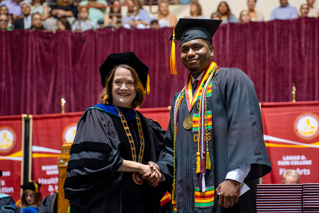Ethan Bailey receives President's Medal from Dr. Haynie