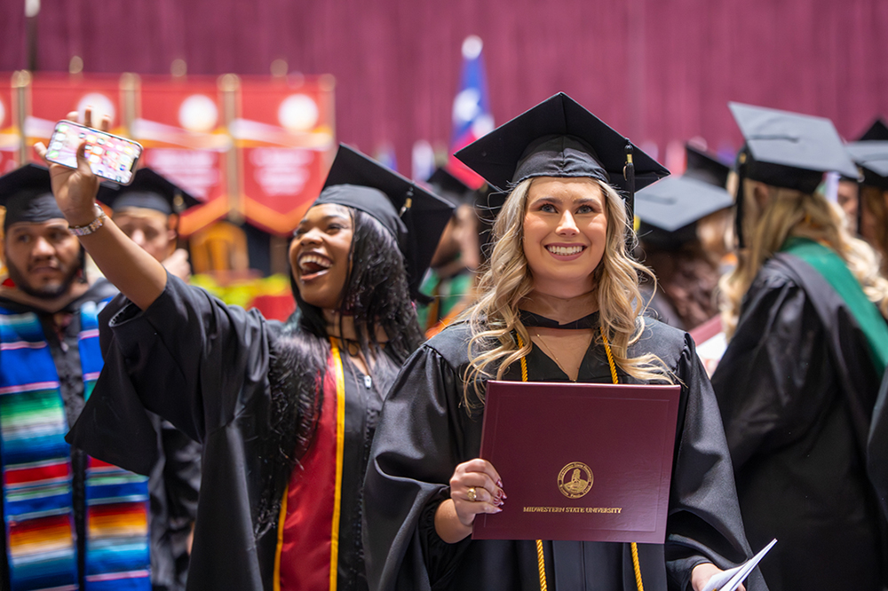 Two graduate school grads are very happy at the Fall 2025 Commencement at D.L. Ligon