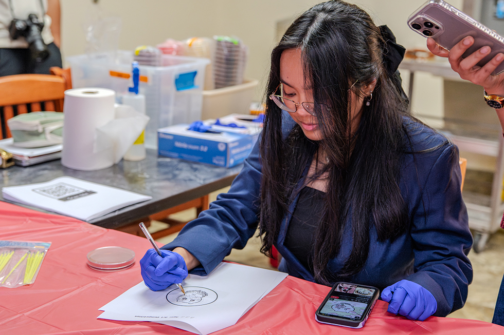 Trinity Munoz, a nursing student researching drug reactions, explores bacteria reactions through the Agar Art Competition.