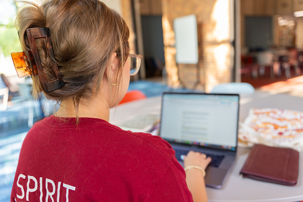 Student facing their computer while working on AI project