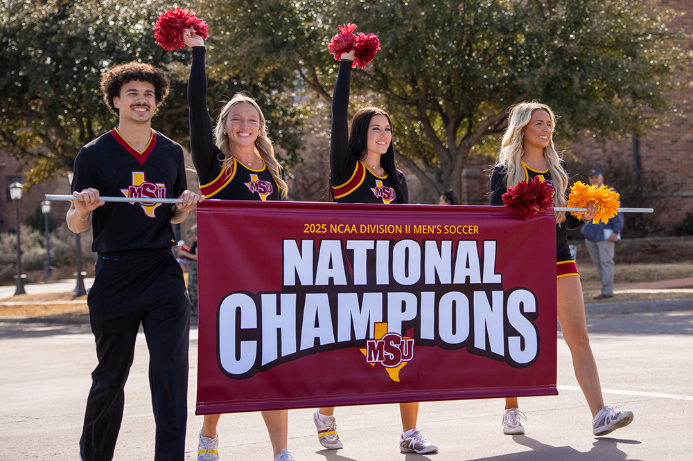 Cheerleaders at the parade hold up a National Champions sign as they walk
