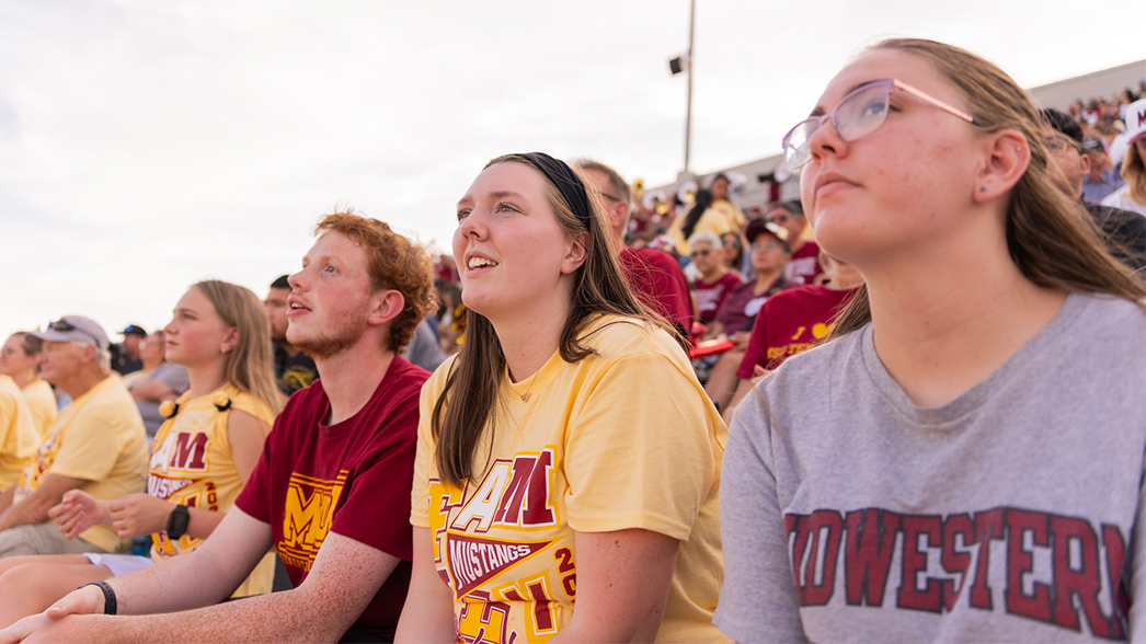 Students in MSU Family Weekend shirts enjoy the football game