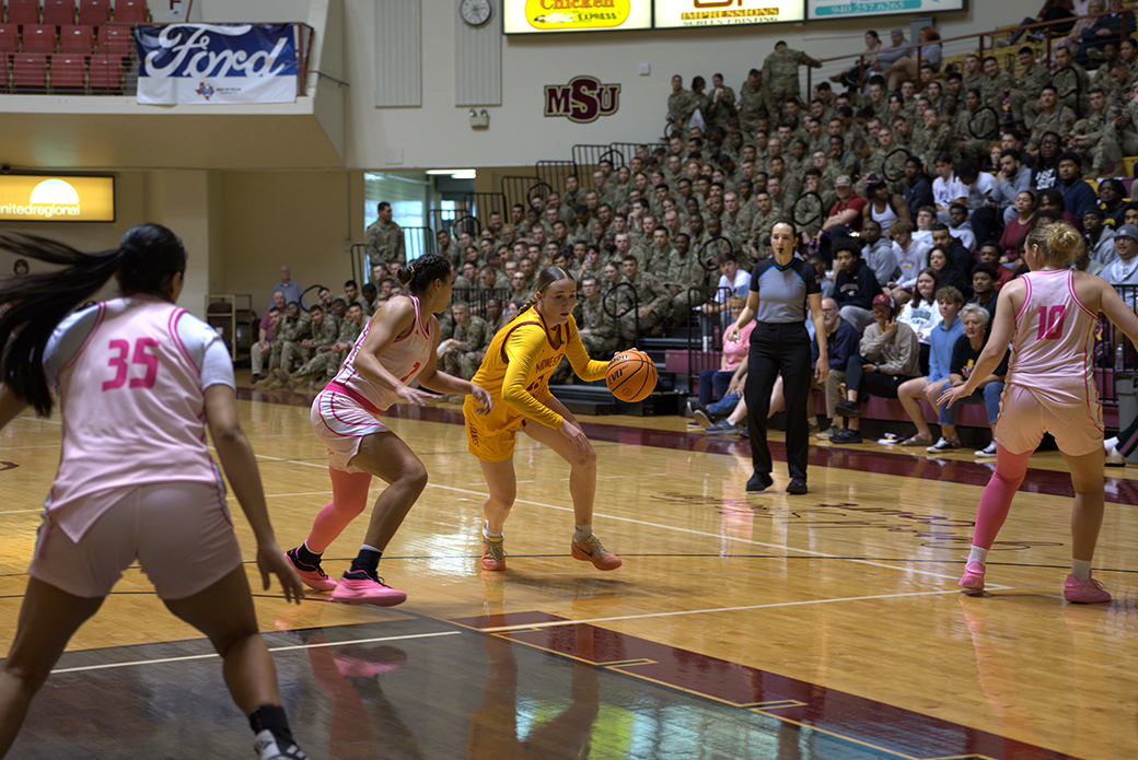 Military members from SAFB helped the Mustangs women defeat Texas A&M-Kingsville Saturday, Feb. 14 at D.L. Ligon Coliseum. On this play, a Mustangs dribbles to the left to go to the basket.