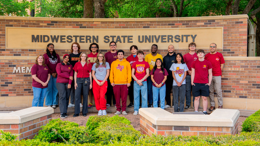 MSU Texas Team Selene poses for photo of entire team in afternoon sunlight in front of MSU Texas sign