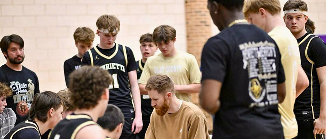 Nick Powell talks to his Henrietta High School basketball team during a timeout