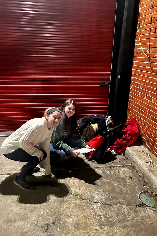 The students in the small group are Sarah Lehman and Angel Adams-Case with a neighbor experiencing homelessness.