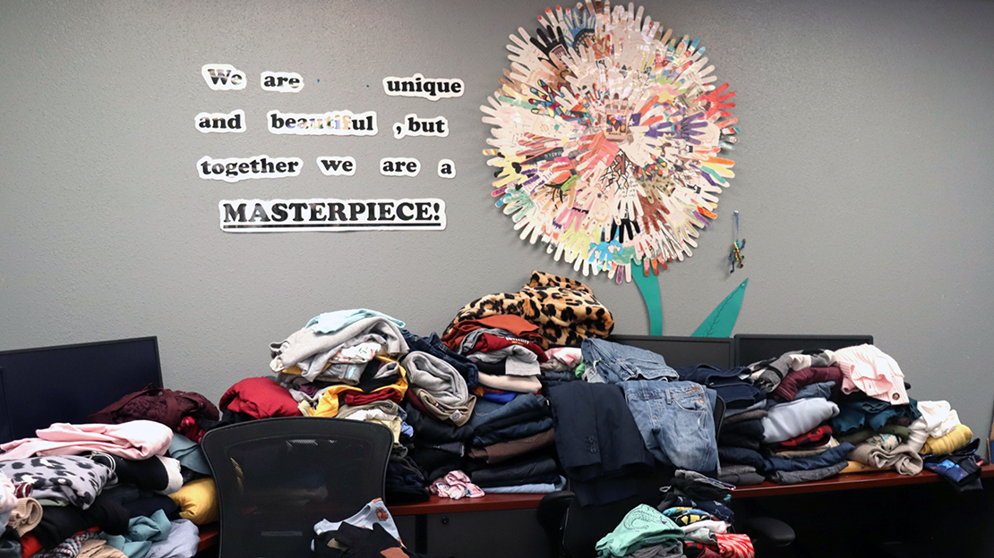 Many piles of clothes donated for the Pop-Up Thrift Shop