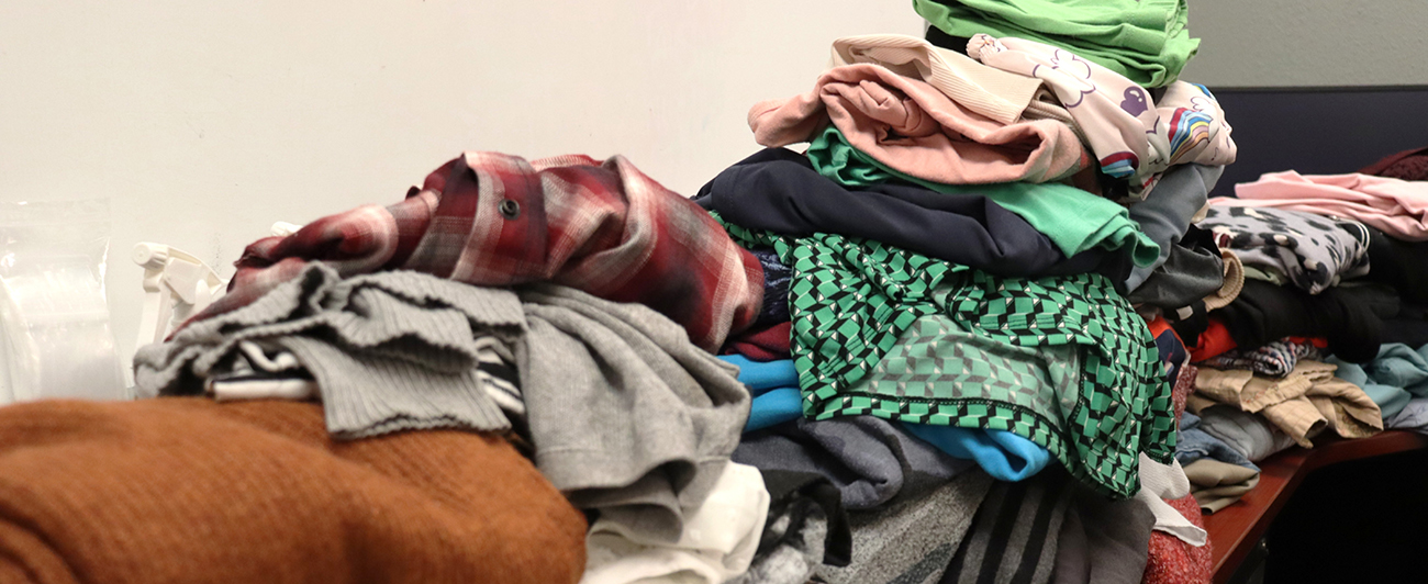 Clothes laying out of various sizes and colors on a table