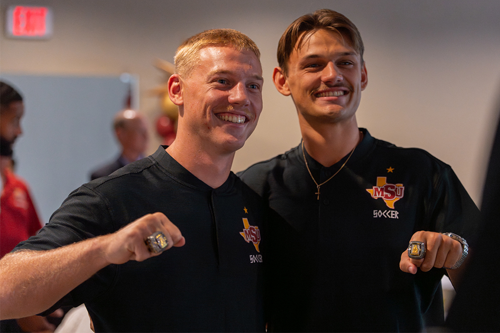 Three Mustangs look down at their championship rings
