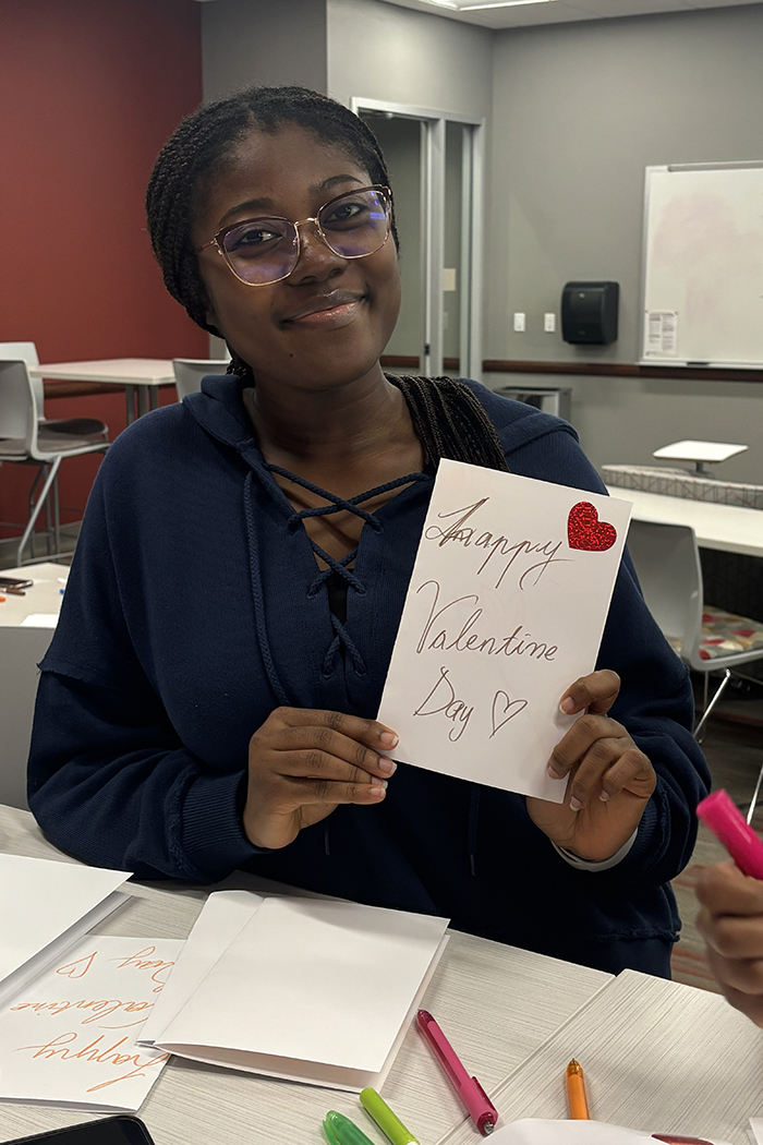 A nursing student shows her Valentine's card she made for seniors