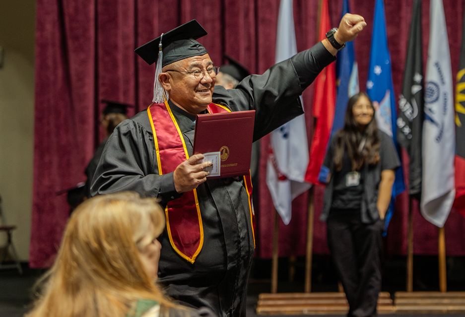 MSU Texas graduate pumps his fist in the Friday night master's graduation ceremony