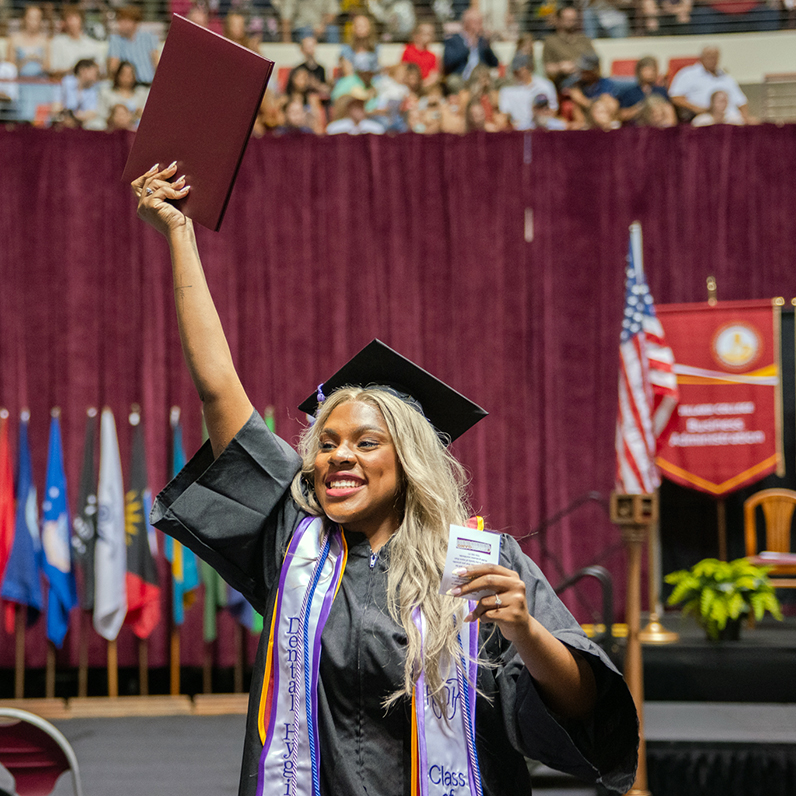 Graduate holds up their diploma at Spring 2026 Commencement Ceremony