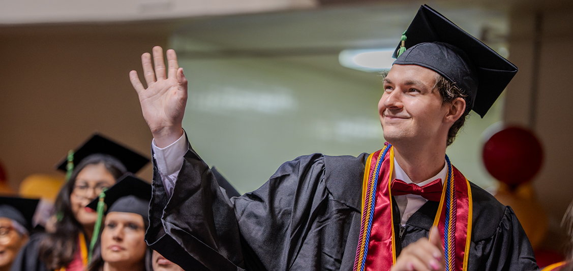 Graduate waves to his supporters at Spring 2026 Commencement